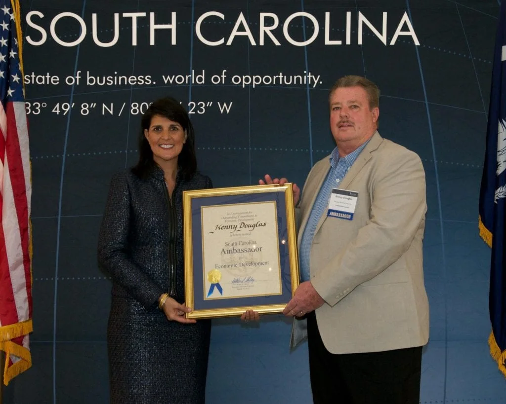 Kenny Douglas receiving an award in an original company photograph